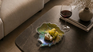 Luxury fused glass dinnerware with grapes and wine on a modern dining table