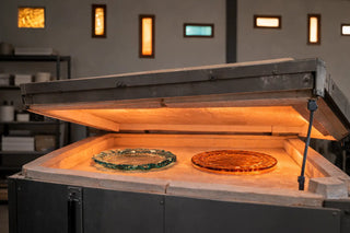 Fused glass plates inside a kiln during the annealing process in a glass studio.