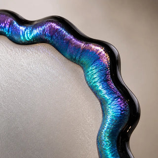 Macro detail of the Obsidian Veil glass edge showing iridescent rainbow tones, textured surface, and dark contour rim.